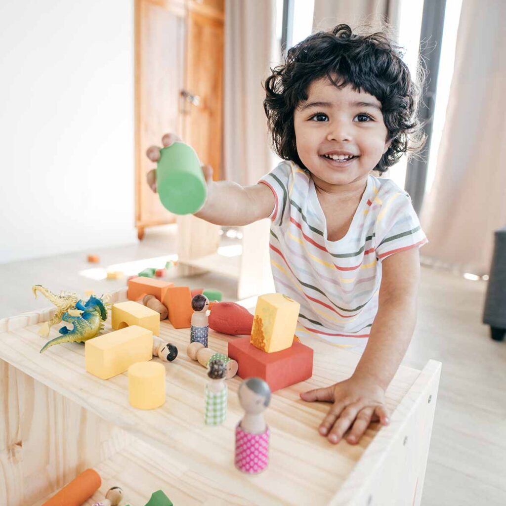 Preschool child smiling and playing with learning development toys