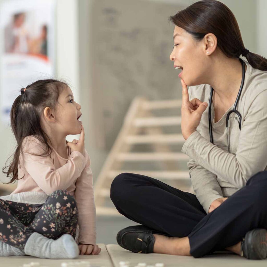 Female speech therapist working with small child